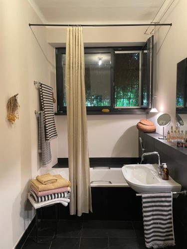 a bathroom with a bath tub and a sink at Casa d'epoca con giardino 5 min da Locarno in Minusio