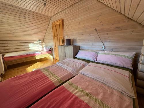 a room with two beds in a log cabin at Sosnowe Domki in Rewal