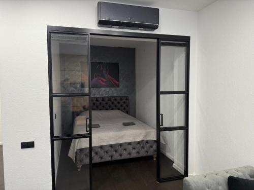 a bedroom with a bed and a tv on a wall at Turgaus 10 in Klaipėda