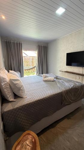a large bed in a room with a window at Vila Gaheri in São Miguel dos Milagres