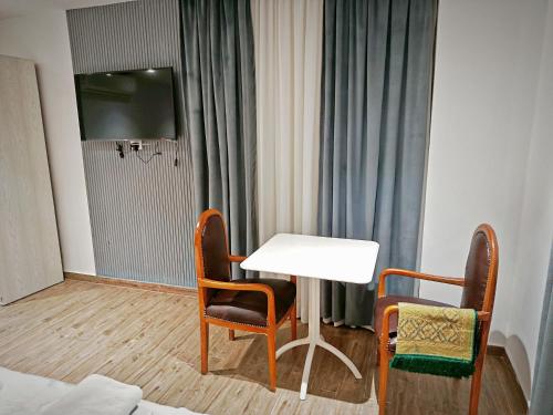 een kamer met een tafel, twee stoelen en een televisie bij Pyrs Giza Heaven in Caïro