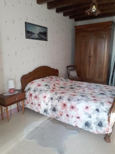 a bedroom with a bed with flowers on it at Gite à Lulu in Châteauvieux