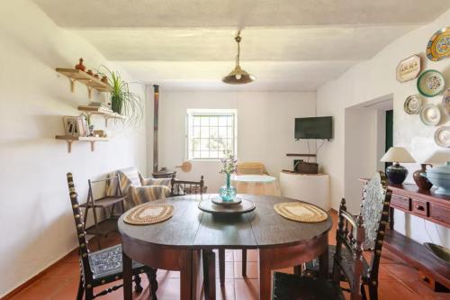 a dining room and living room with a table and chairs at Quinta Casa Seleiras in Évora