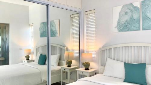 a bedroom with two beds and a mirror at Penthouse Residence 8 Suite 2 in Nathon Bay