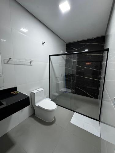 a bathroom with a toilet and a glass shower at Villa Hotel in Bom Jesus da Lapa