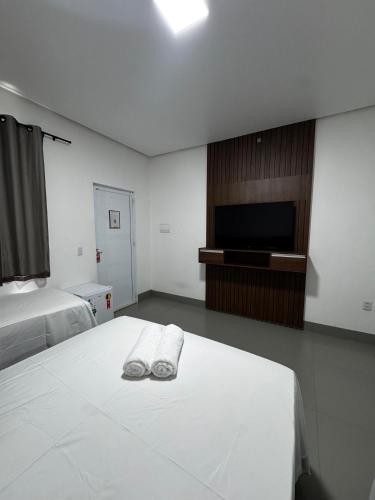 een hotelkamer met een bed en een flatscreen-tv bij Villa Hotel in Bom Jesus da Lapa