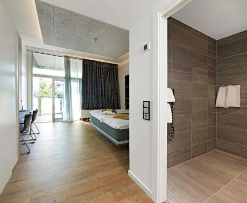 a bedroom with a bed and a walk in shower at Living Suites in Nærum