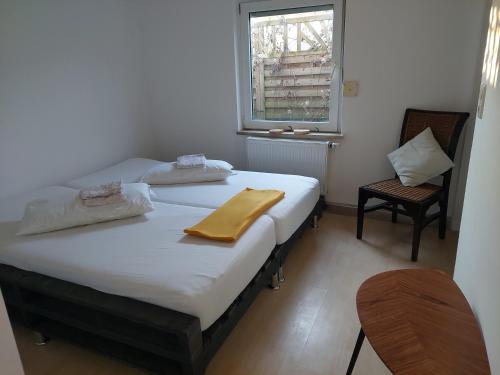 two beds in a room with a chair and a window at Ferienhaus Auszeit in Höchstädt an der Donau