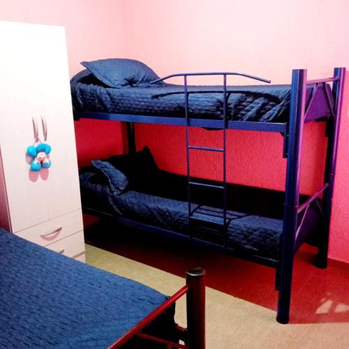 a room with two bunk beds and a table at Brisas de las Sierras in Tanti