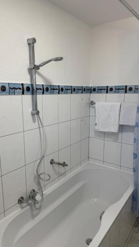 a bath tub with a shower in a bathroom at Gemütliche, lichtdurchflutete Wohnung in Karlsruhe