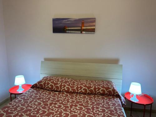 een slaapkamer met een bed met twee rode tafels bij Casa Cristina in Marino