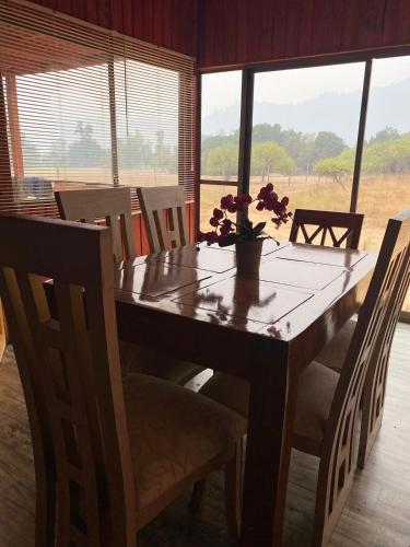 une table en bois avec un vase de fleurs dessus dans l'établissement Cabañas Vega del Molino, à Linares