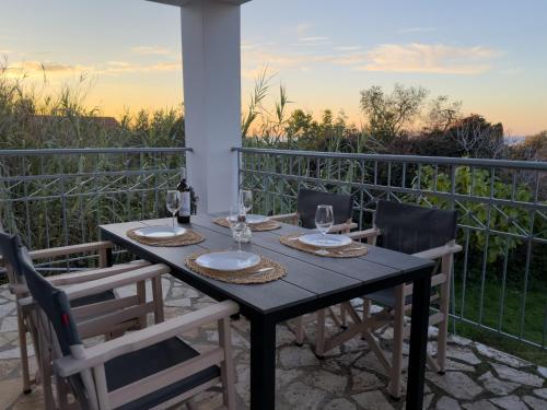 een tafel en stoelen op een balkon met uitzicht bij Artemis Villa in Fiskardho