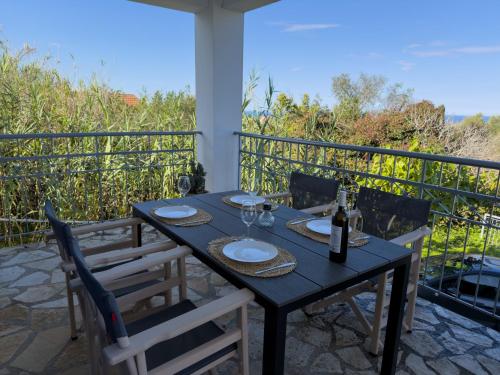 een tafel met glazen en wijnflessen op een balkon bij Artemis Villa in Fiskardho