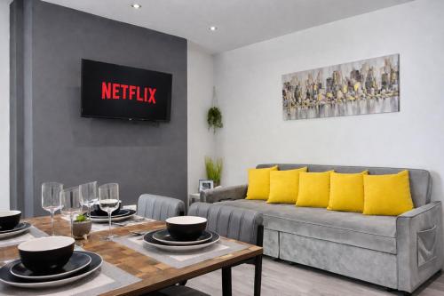 a living room with a couch and a table at Emerald Living, 4 bedrooms, sleeps 6, free parking, close to centre and beaches! in Swansea