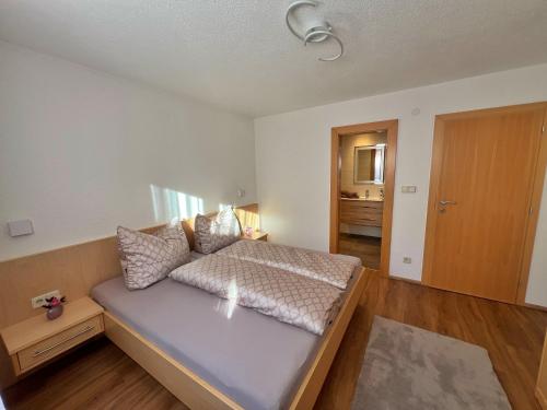 a bedroom with a bed with pillows on it at Appart Leni in Pfunds