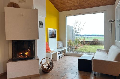 a living room with a fireplace and a couch at Charming house with mountain view in Hämikon