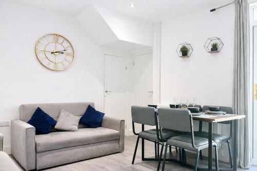 a living room with a couch and a table with chairs at Emerald Living, 4 bedrooms, sleeps 6, free parking, close to centre and beaches! in Swansea
