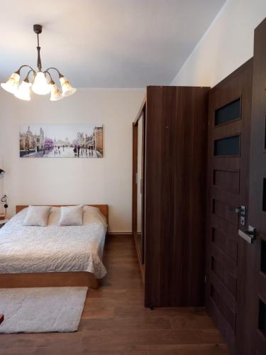 a bedroom with a bed and a chandelier at Studio Szczawienko 2 in Wałbrzych