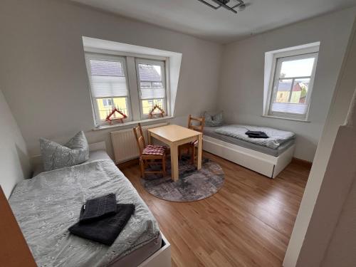 ein kleines Zimmer mit einem Bett und einem Tisch in der Unterkunft Ferienwohnung Unger in Großhartmannsdorf