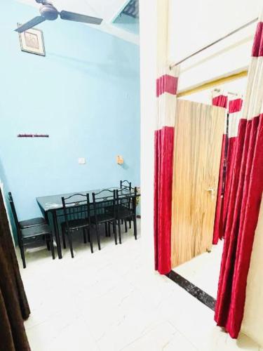 a dining room with red curtains and a table at Bajrang kutirr in Varanasi
