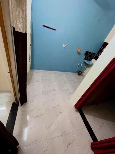 a room with a blue wall and a tile floor at Bajrang kutirr in Varanasi