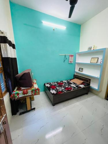 a bedroom with a bed and a chair in a room at Bajrang kutirr in Varanasi