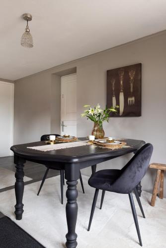 Bennekom居住区住宿加早餐旅馆的一间用餐室,配有一张黑桌子和一把椅子