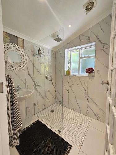 a bathroom with a shower and a sink at Cherry Tree House, Newlands in Cape Town