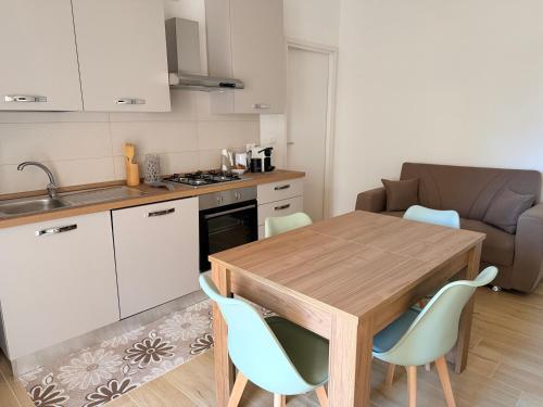 een kleine keuken met een houten tafel en stoelen bij La DA MA Shila Winter Escape in Francavilla al Mare