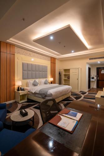 a bedroom with a large bed and a living room at فندق هورايزون-Horizon Hotel in Najran