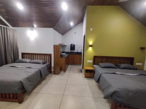 1 Schlafzimmer mit 2 Betten und einer grünen Wand in der Unterkunft The Vagabond Stays in Vagamon