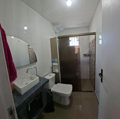 a bathroom with a sink and a toilet and a shower at Mini Casa Mezanino in São Francisco do Sul