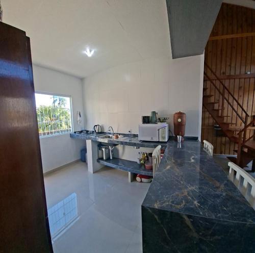 a kitchen with a counter and a table in a room at Mini Casa Mezanino in São Francisco do Sul
