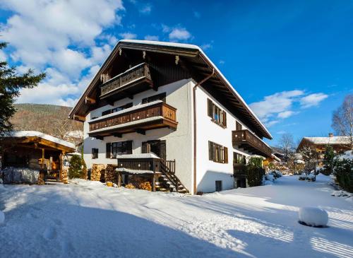ein Gebäude mit Schnee auf dem Boden davor in der Unterkunft Ferienwohnung "Hochfeld Seeblick" in Tegernsee