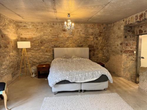 a bedroom with a bed and a stone wall at La Grotta in Hinkel