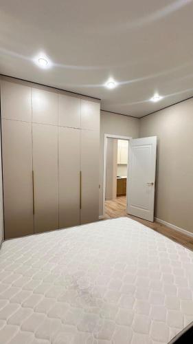een lege kamer met een groot bed en een kledingkast bij Angel apart in Astana