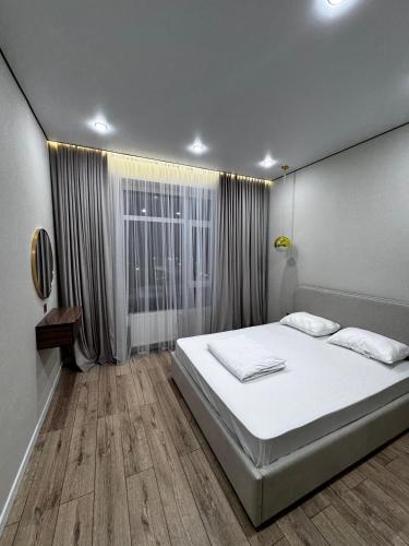een slaapkamer met een wit bed en een raam bij Angel apart in Astana