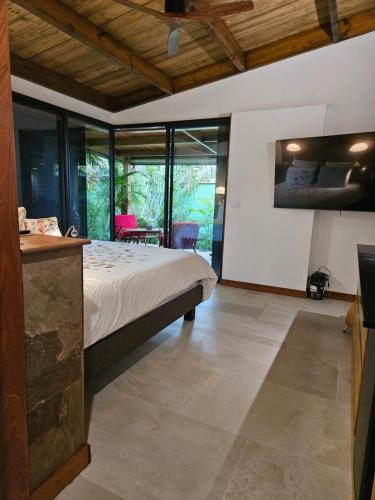 een slaapkamer met een bed in een kamer met ramen bij Bois de Songe in Sainte-Rose