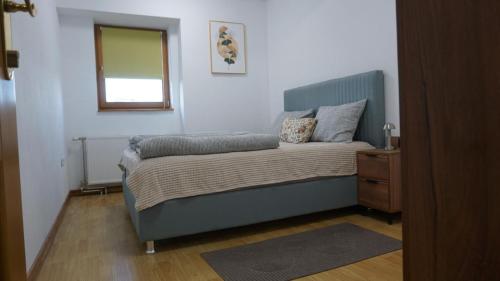 a bedroom with a bed with a mirror and a window at Apartmani Flocke Vlašić in Šišava