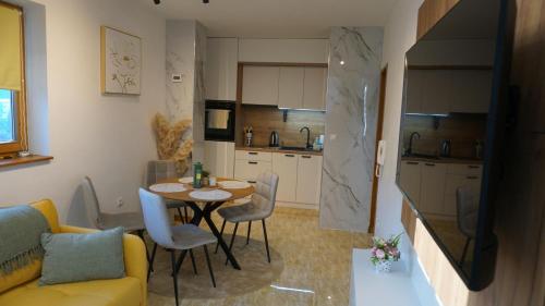 a kitchen with a table and chairs in a room at Apartmani Flocke Vlašić in Šišava