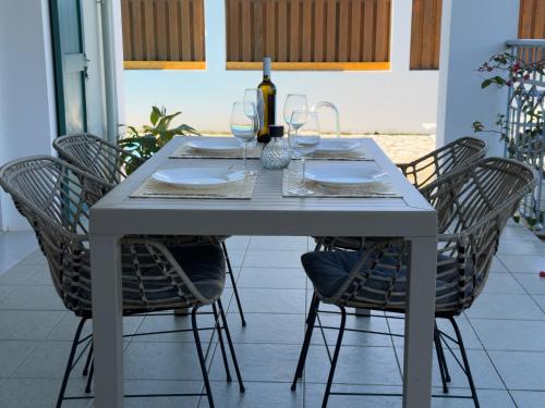 a table with chairs and a bottle of wine on it at Regina Villa in Fiskardo