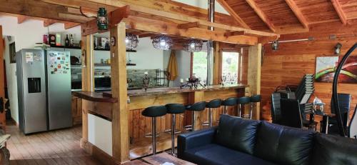 una cucina con un bar con frigorifero di CASA CON PLAYA PUCURA a Licán Ray