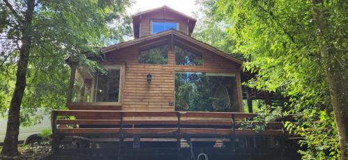 una cabina in legno al centro degli alberi di CASA CON PLAYA PUCURA a Licán Ray