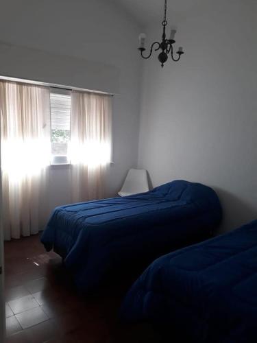 a bedroom with two beds and a chandelier at Casa de la Bove in La Cumbre