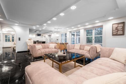 a living room with couches and a table at NEU! HeideVilla - Private Pool, Sauna & Mini Golf in Asendorf