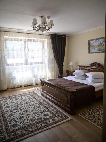 a bedroom with a large bed and a large window at Restaurant Casa Barsan in Bîrsana