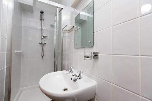 biała łazienka z umywalką i prysznicem w obiekcie Station Approach w mieście Solihull