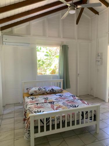 a bedroom with a bed in a room with a window at BRADA gites in Deshaies