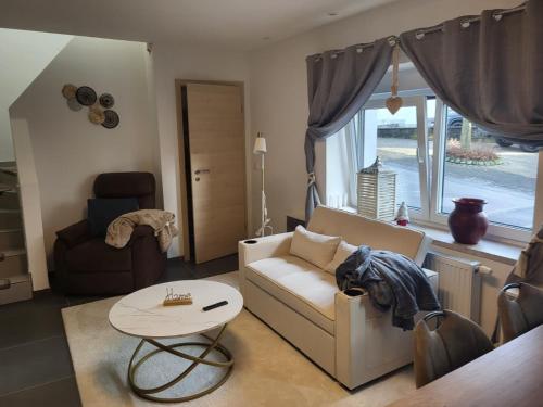 een woonkamer met een bank en een tafel bij Ferienhaus Neunkirchen-Daun in Daun